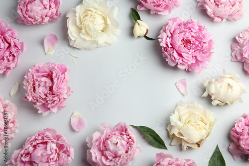 Frame made of beautiful peonies on light grey background, flat lay. Space for text © New Africa