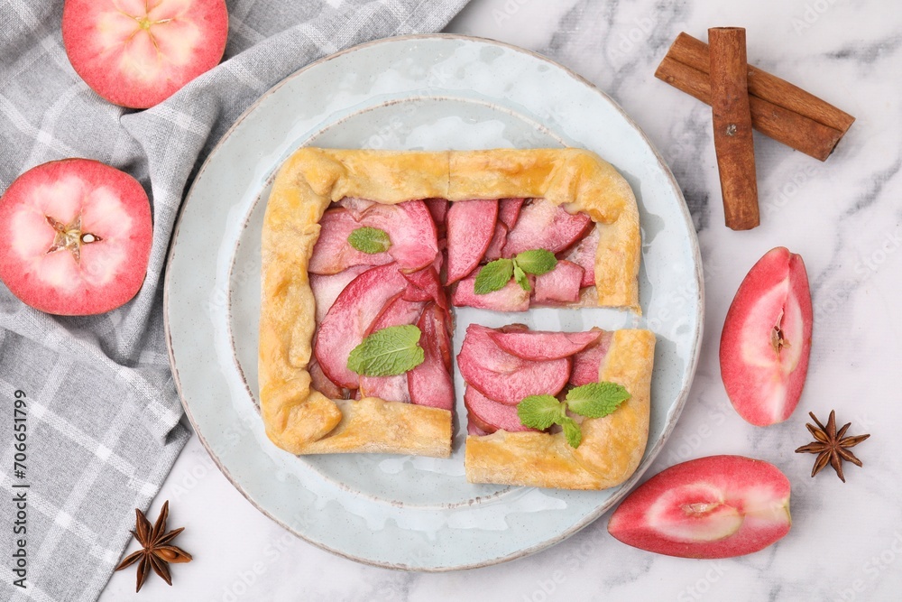 Delicious apple galette with mint and ingredients on white marble table, flat lay