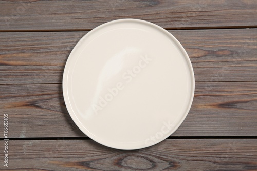One ceramic plate on grey wooden table, top view