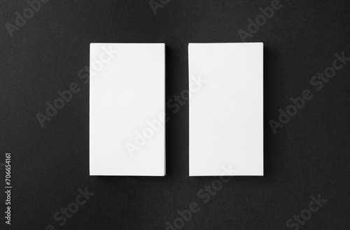 Blank business cards on black background, flat lay. Mockup for design
