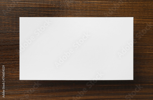 One blank business card on wooden table, top view. Mockup for design