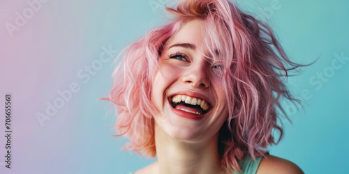 Close-up of a young woman with vibrant pink hair, laughing joyfully against a striking blue background, embodying freedom and happiness..