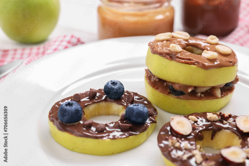 Fresh apples with nut butters, blueberries and nuts on plate, closeup Fresh apples with nut butters, blueberries and nuts on plate, closeup