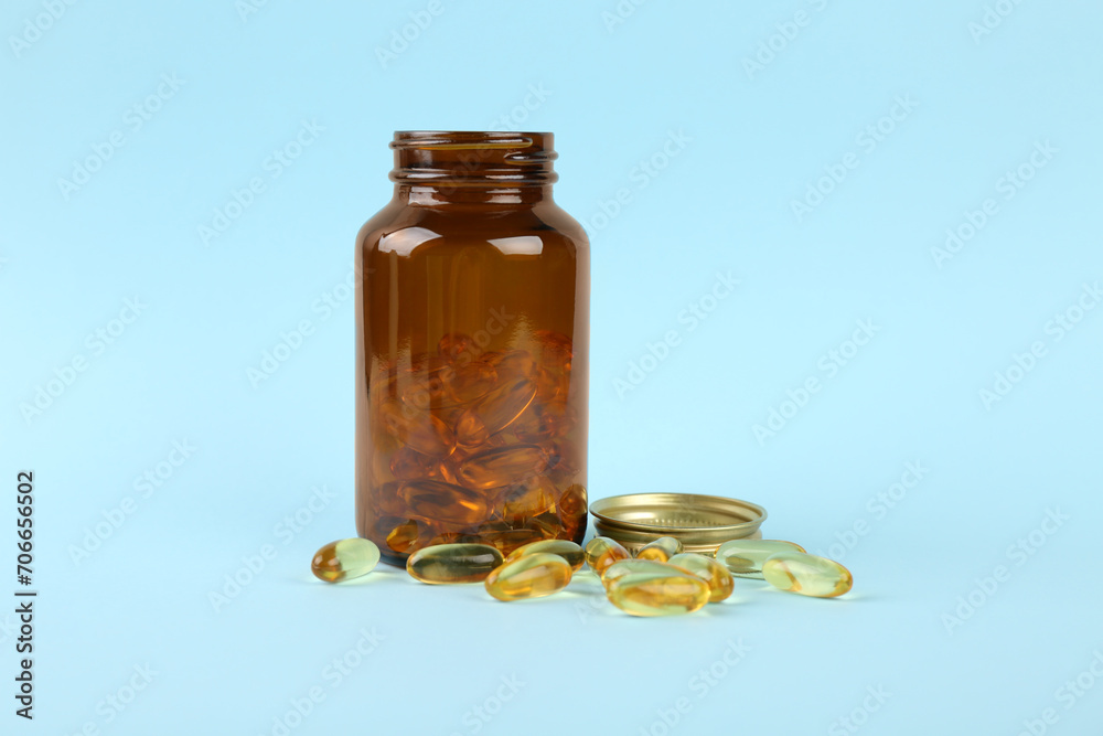 Jar with vitamin capsules on light blue background Jar with vitamin capsules on light blue background