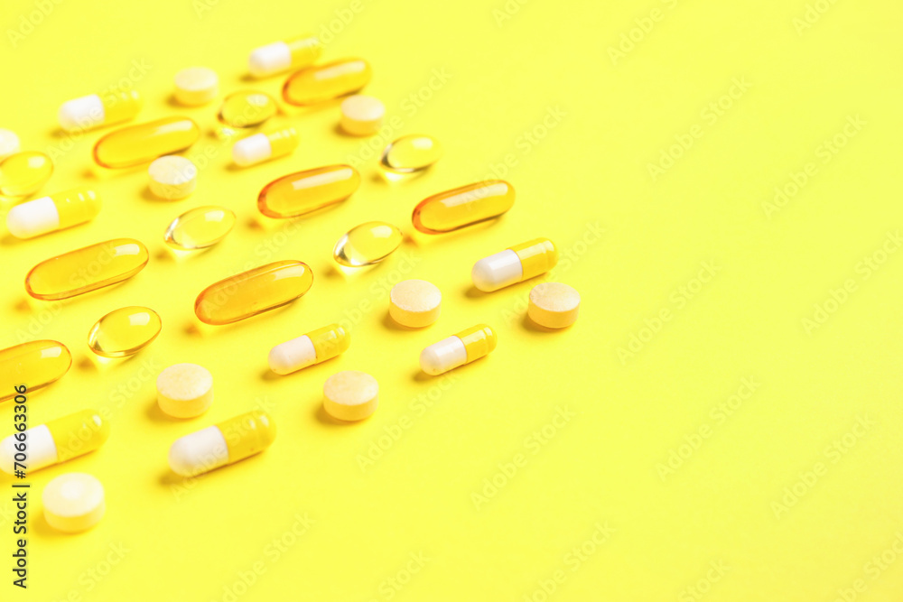 Different pills on yellow background, closeup Different pills on yellow background, closeup