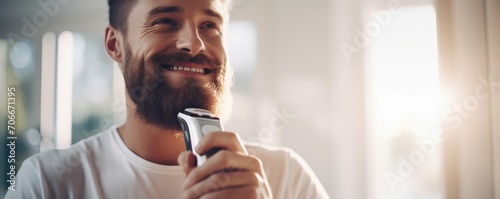 Fotografie, Obraz Happy man shaves his beard with a shaving machine