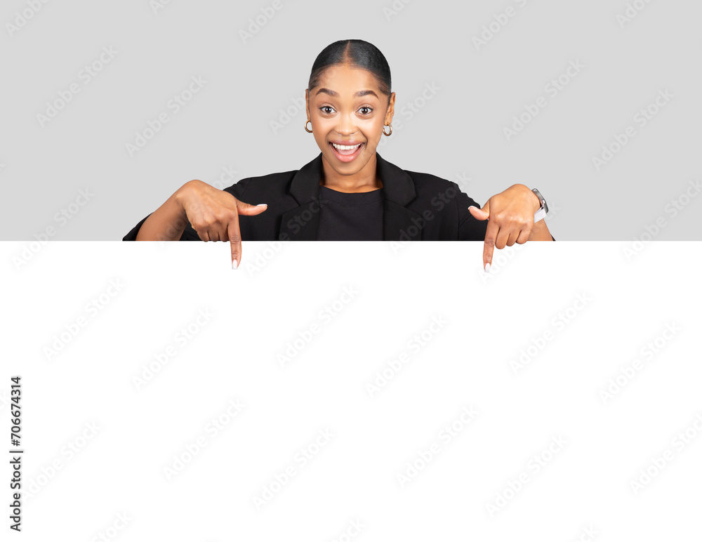 Professional African American woman in a business suit happily pointing downwards to a blank promotional space Professional African American woman in a business suit happily pointing downwards to a blank promotional space