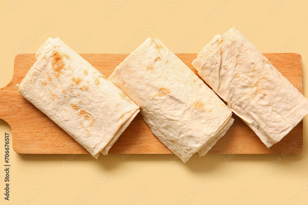 Board with fresh thin lavash on beige background Board with fresh thin lavash on beige background