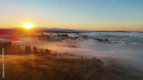 Golden sunrise over farms covered in mist