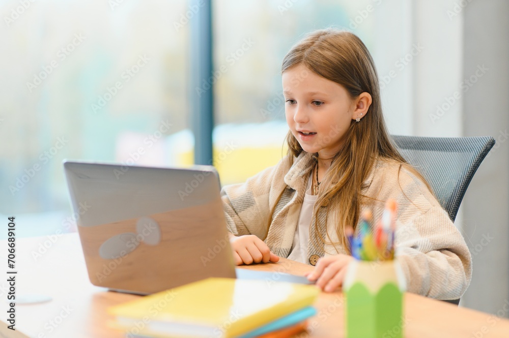 Smiling little Caucasian girl have video call distant class with teacher Smiling little Caucasian girl have video call distant class with teacher