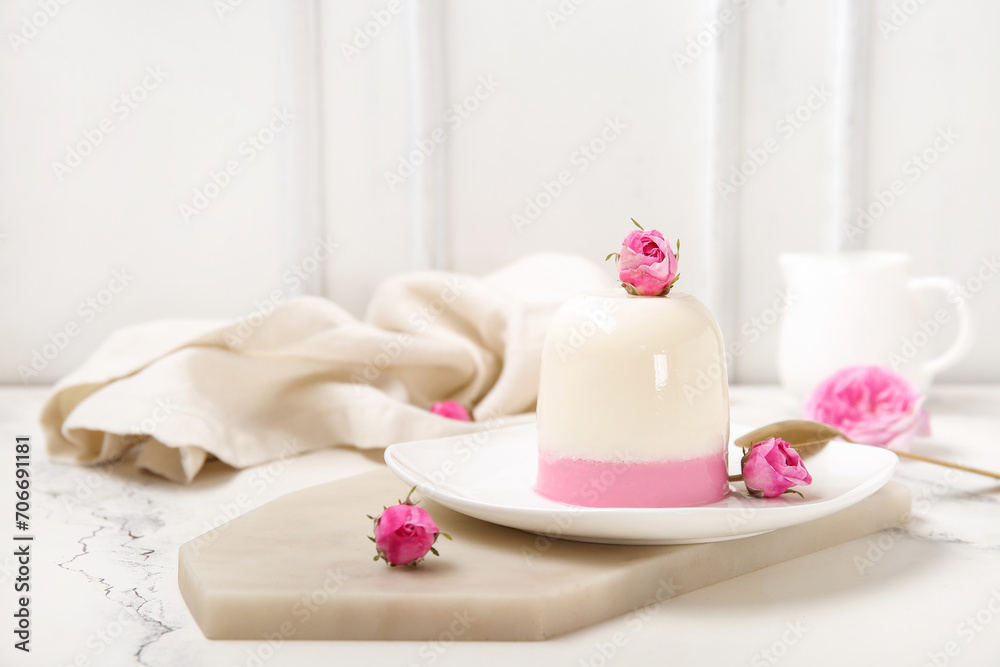 Plate of panna cotta with beautiful pink rose flowers on white table