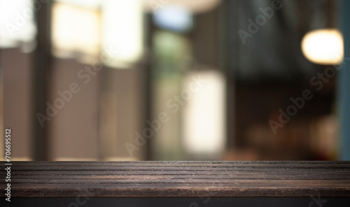 Fototapeta Naklejka Na Ścianę i Meble -  Empty dark wooden table in front of restaurant abstract blurred bokeh background. can be used to demonstrate or mount your products. Layout for space