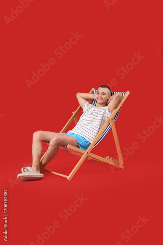 Happy young man sitting on ...
