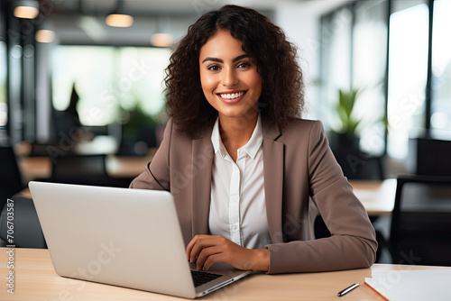 Joyful Latina Businesswoman Engaged with Laptop, Pondering Advanced AI Corporate Strategies in Offic