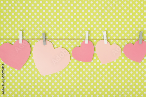 Pink paper hearts hanging at a rope for Valentine's Day, Mother's Day or Women's Day decoration with copy space 