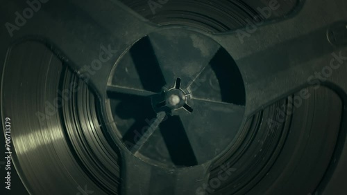 Extreme closeup of a vintage recorder reel. Closeup of a playing reel-to-reel recorder. Slowmotion, footage 4K.  photo
