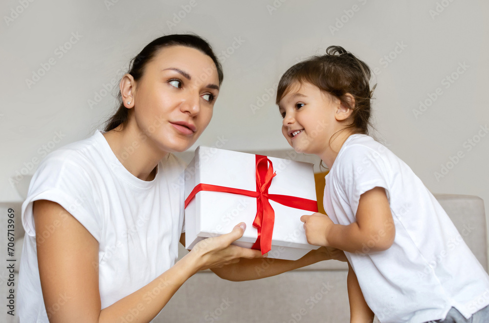 Surprise Gift. Excited Mother And Little Daughter Shaking Wrapped Box With Present Surprise Gift. Excited Mother And Little Daughter Shaking Wrapped Box With Present