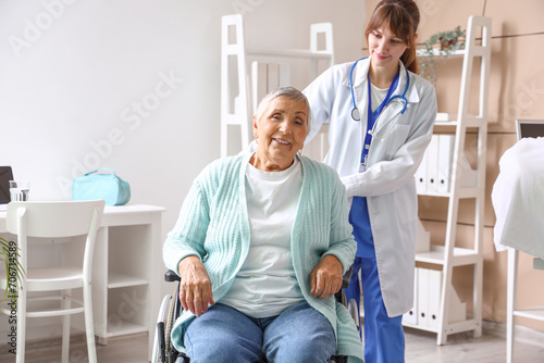 Senior woman in wheelchair with doctor at nursing home