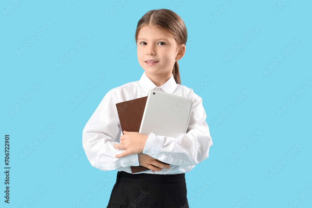 Cute little businesswoman with tablet computer and notebook on blue background. Opposite Day celebration Cute little businesswoman with tablet computer and notebook on blue background. Opposite Day celebration