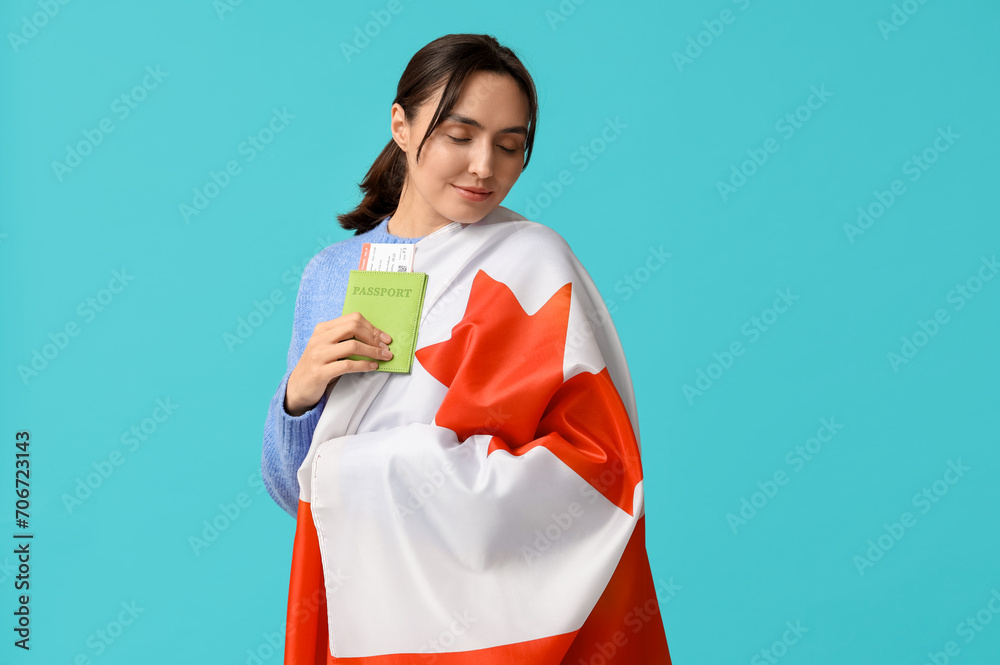 Pretty young woman with flag of Canada and passport on blue background. Immigration concept Pretty young woman with flag of Canada and passport on blue background. Immigration concept