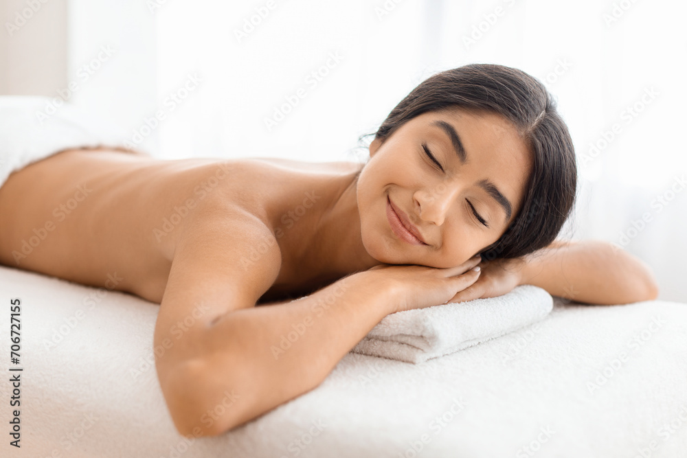 Relaxed young indian woman resting after healing back massage Relaxed young indian woman resting after healing back massage