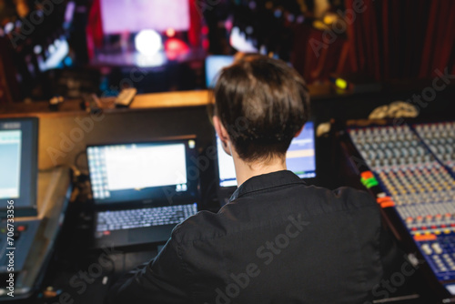View of lighting technician operator working on mixing console workplace during live event concert on stage show broadcast, light mixer controller panel, sound technician with professional equipment