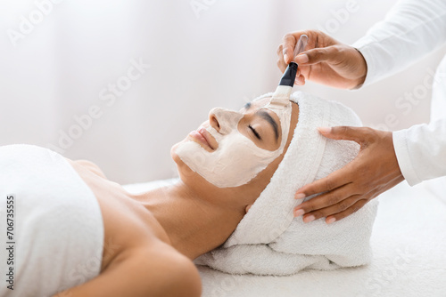 Tranquil woman with facial treatment at day spa photo