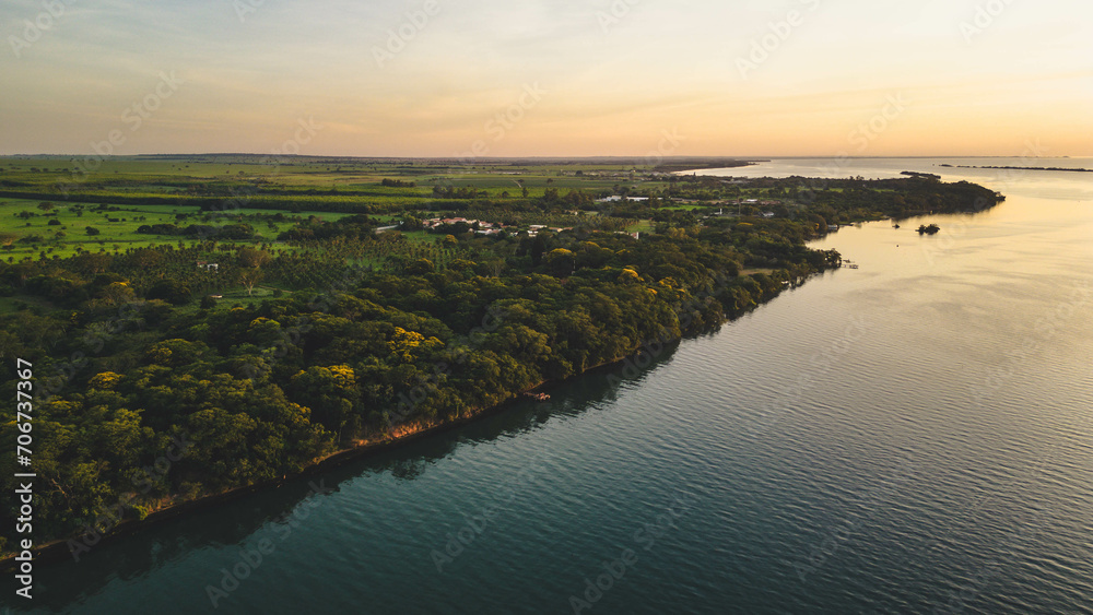 Aerial view of Parana River or Rio Parana in the shore of Panorama city in the state of Sao Paulo during a golden sunset - Brazil
