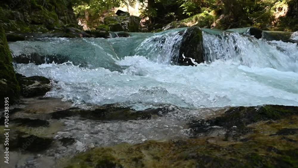 Slow motion of water running over rocks of a mountain stream Slow motion of water running over rocks of a mountain stream