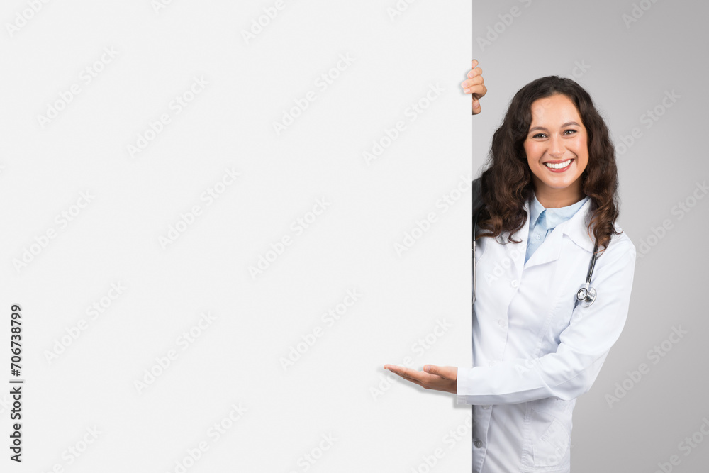 Doctor woman presenting behind blank white board Doctor woman presenting behind blank white board