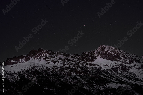 Majestic snow-covered mountains under starry night sky photo