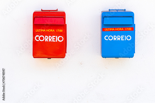 two mailboxes, one red plain mail, one blue express mail under white wall. 5pm last minute notice photo