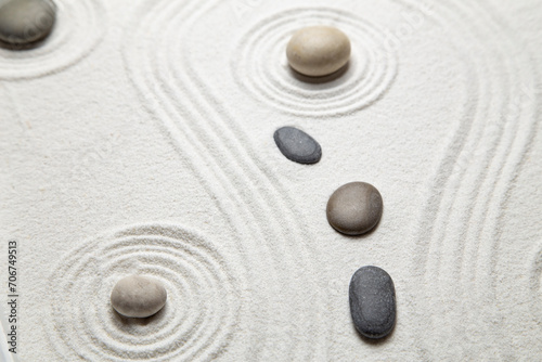 Zen garden with the stones and white sand pattern