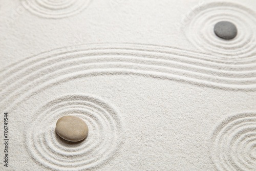 Zen garden with the stones and white sand pattern