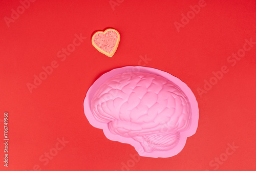 Brain in love concept flat lay still life of pink brain and sparkling red hearts on red background