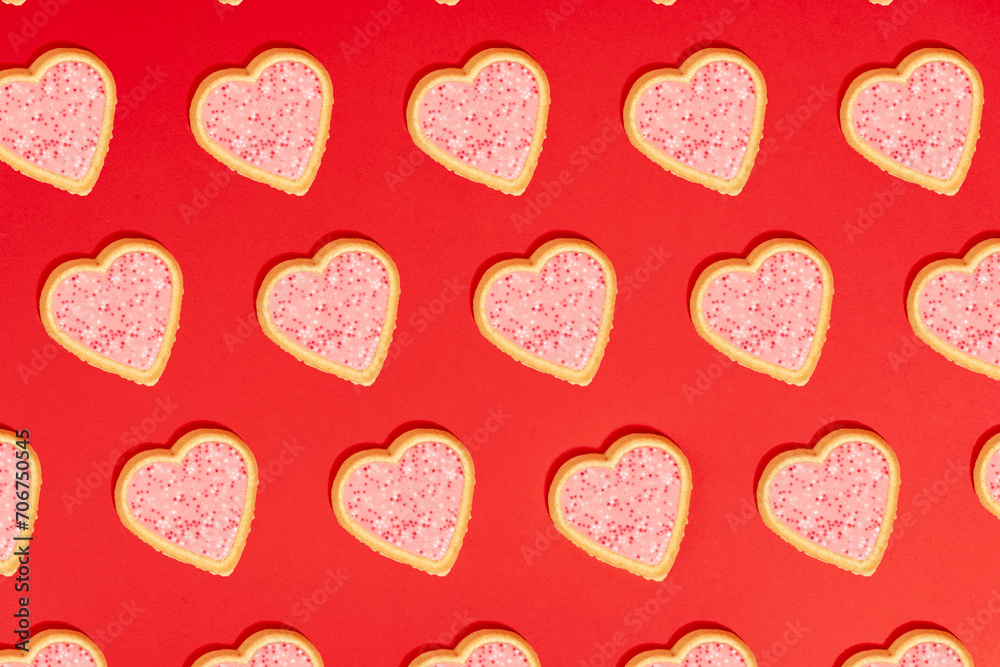 Fototapeta premium Patterned heart shaped strawberry cookies St Valentine flat lay concept on red background