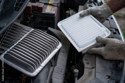 The master changes the air filter in the car engine. 