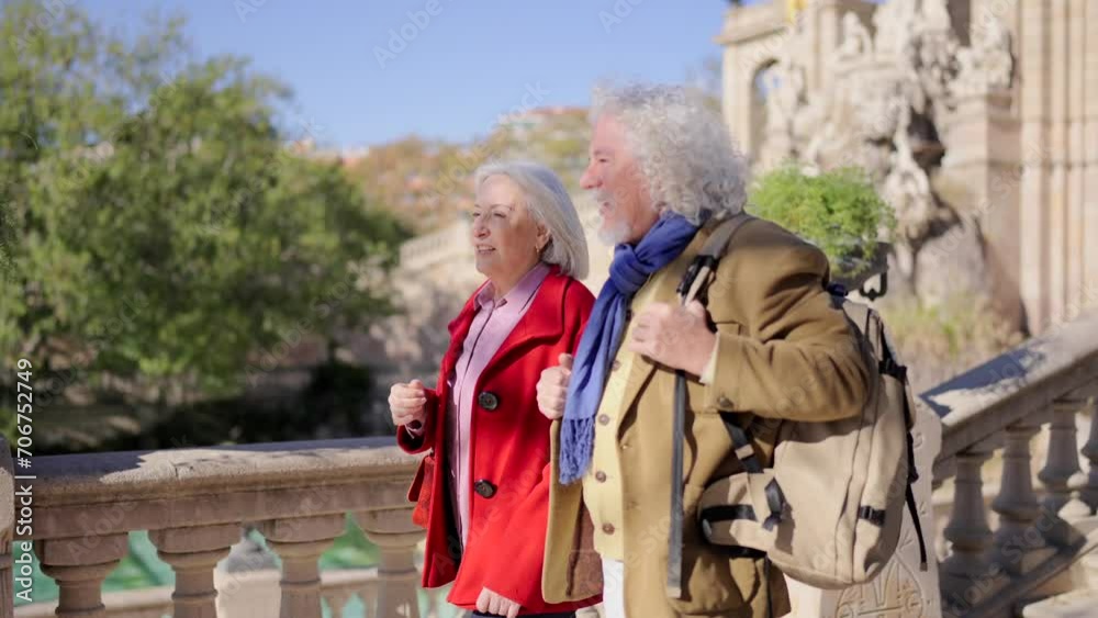 Video of two senior tourists visiting a beauty urban park with a fountain in a sunny cold day Video of two senior tourists visiting a beauty urban park with a fountain in a sunny cold day