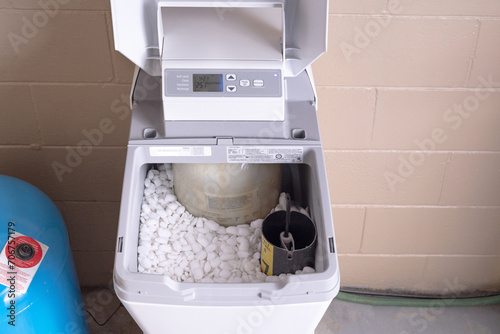 Water softener with lid open. Water softener with salt pellets in the tank