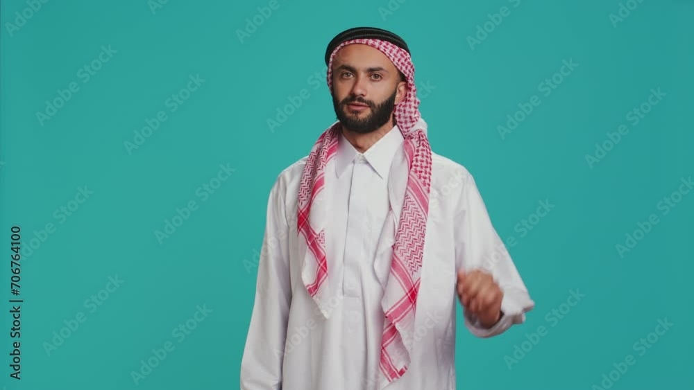 Middle eastern person does stop sign with palm up, expressing refusal and denial on studio camera. Young man presenting rejection symbol, being displeased and disappointed. Middle eastern person does stop sign with palm up, expressing refusal and denial on studio camera. Young man presenting rejection symbol, being displeased and disappointed.