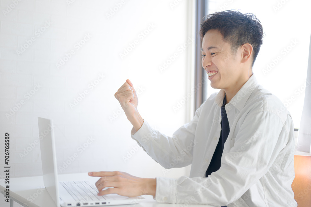 PCを指さして喜ぶ男性