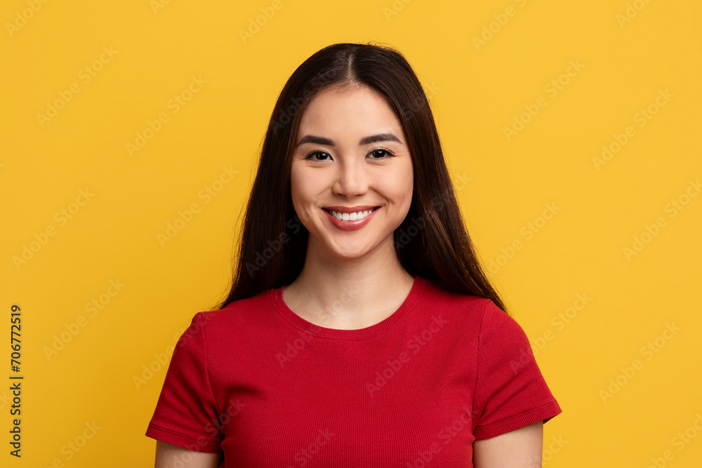 Portrait of attractive young asian woman posing on yellow background Portrait of attractive young asian woman posing on yellow background