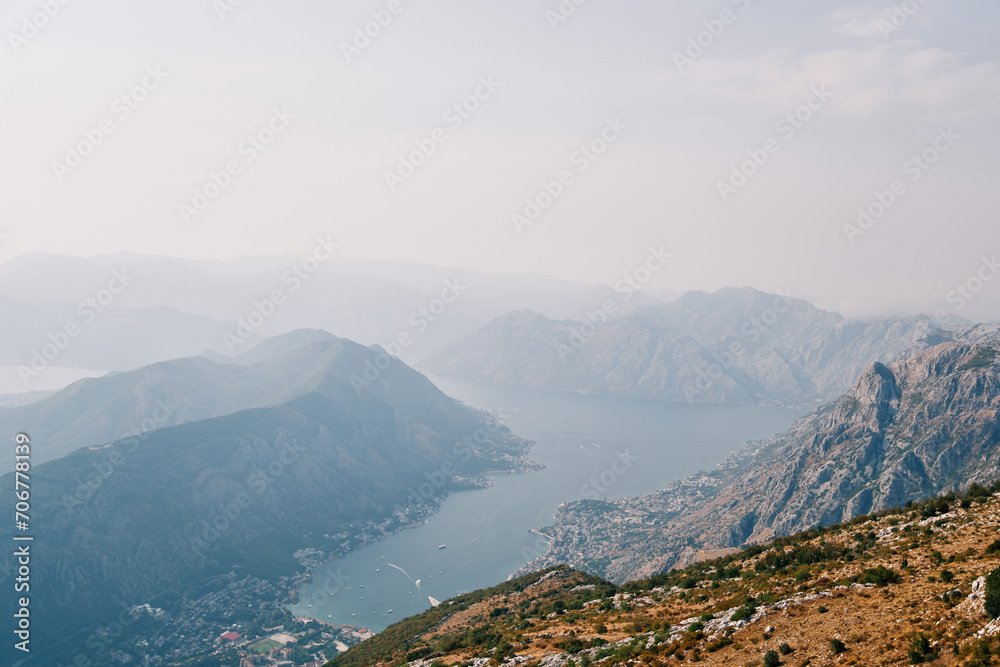 View from the mountain of the valley of the Bay of Kotor surrounded by a mountain range in a light haze. Montenegro