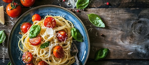 The classic tagliatelli pasta with tomato sauce is served on a blue plate Italian dish with tomatoes basil parmesan and pasta top view. with copy space image. Place for adding text or design photo