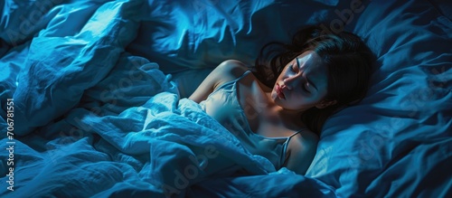 Stressed woman on bed late at night suffering from insomnia sleep apnea or stress Top view of depressed girl lying in bed late at night High angle view of awake girl in the middle of the night photo