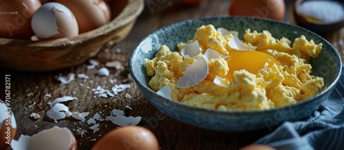 Scrambled eggs with brown egg shells in a bowl behind. with copy space image. Place for adding text or design