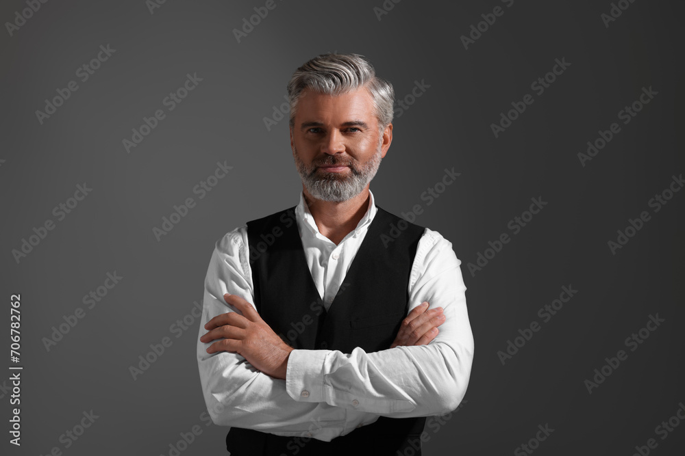 Portrait of confident man with beautiful hairstyle on dark background