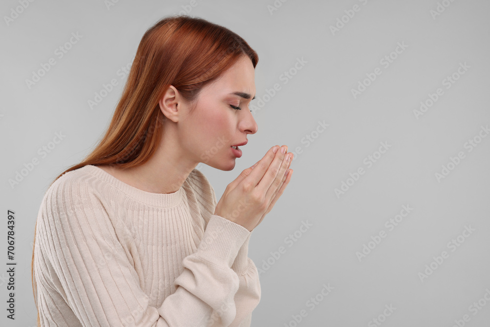 Woman coughing on light grey background, space for text. Cold symptoms Woman coughing on light grey background, space for text. Cold symptoms