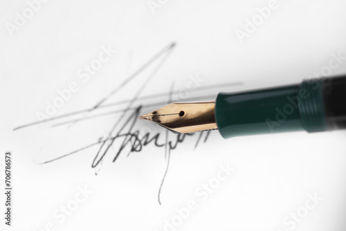 Fountain pen and signature on sheet of paper, closeup