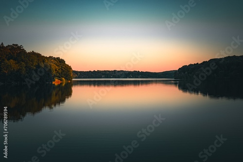 Landscape of peaceful area covered with trees and reflecting in still water